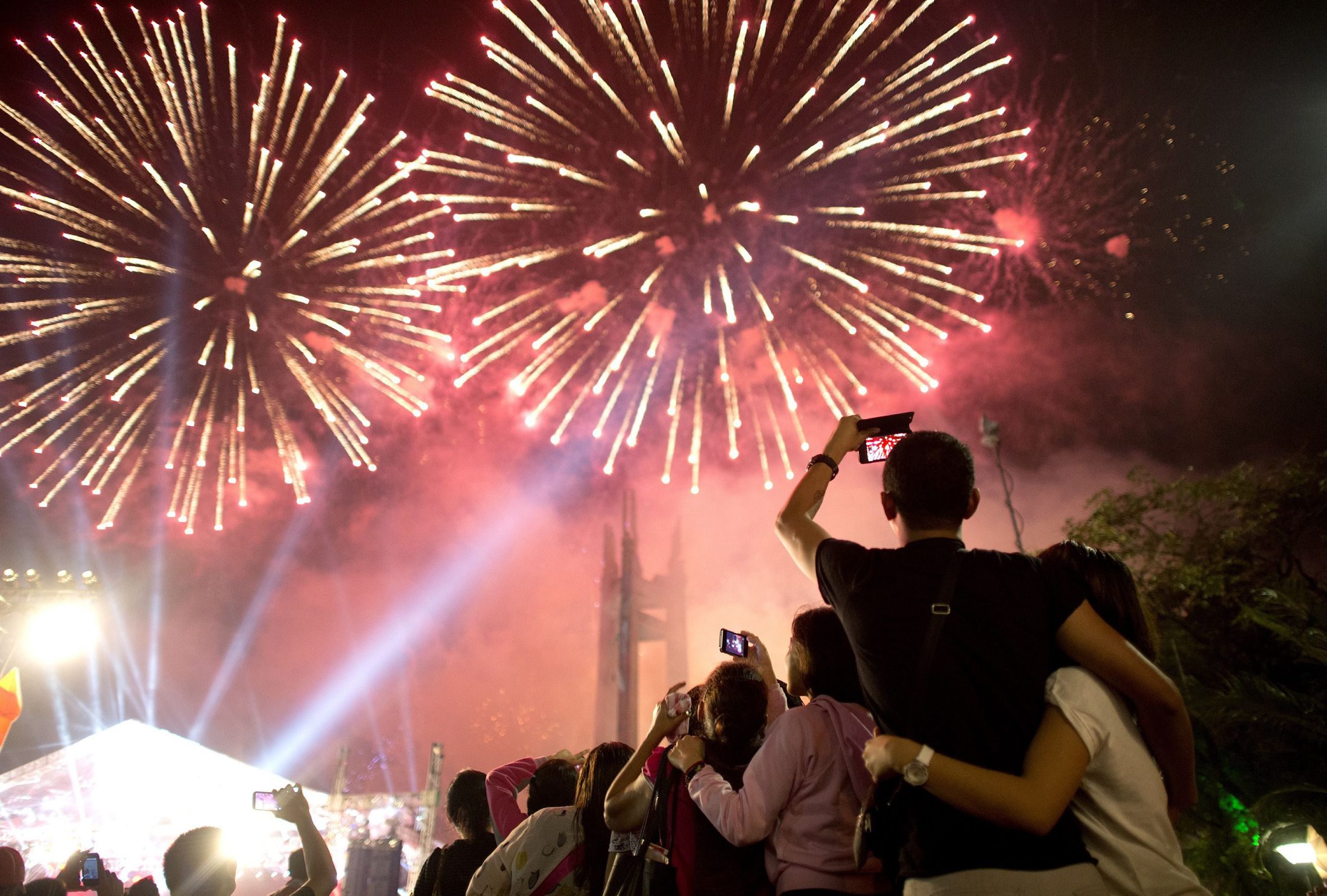 People look at fireworks during a New Year Celebration in Manila on January 1, 2015. The Philippines is mainly Roman Catholic but the celebrations draw on ancient superstitions and Chinese traditions in which the noise from firecrackers is meant to drive away evil spirits and bring good luck in the coming year. Philippine authorities said more than 260 people had been injured by fireworks, firecrackers or stray bullets in the days leading up to New Year's Eve.    AFP PHOTO / NOEL CELIS